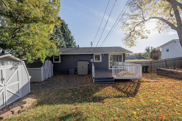 rear view of property with a wooden deck, a storage shed, a lawn, and central AC unit