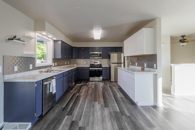 kitchen featuring decorative backsplash, dark hardwood / wood-style flooring, white cabinetry, sink, and stainless steel appliances