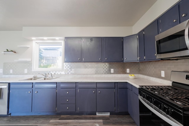 kitchen with stainless steel appliances, tasteful backsplash, sink, and dark hardwood / wood-style floors