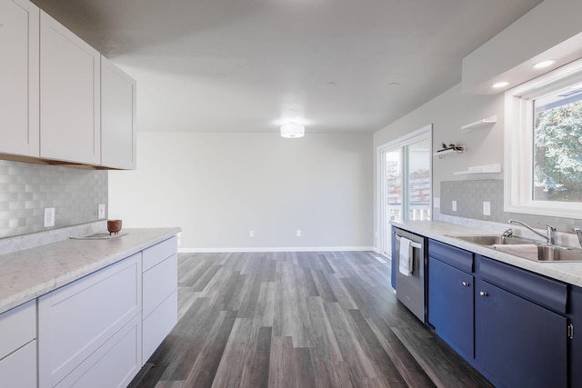 kitchen featuring white cabinets, stainless steel dishwasher, sink, and a wealth of natural light