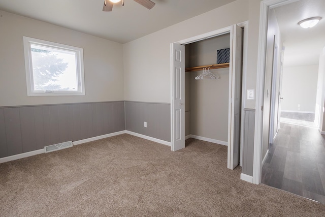 unfurnished bedroom with a closet, ceiling fan, and carpet