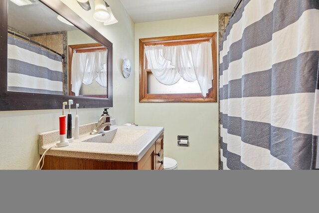 bathroom with vanity, toilet, and walk in shower