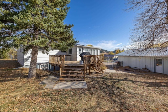 back of house with a deck and a lawn