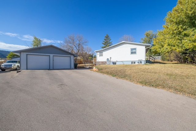 view of home's exterior with a yard, an outdoor structure, and a garage