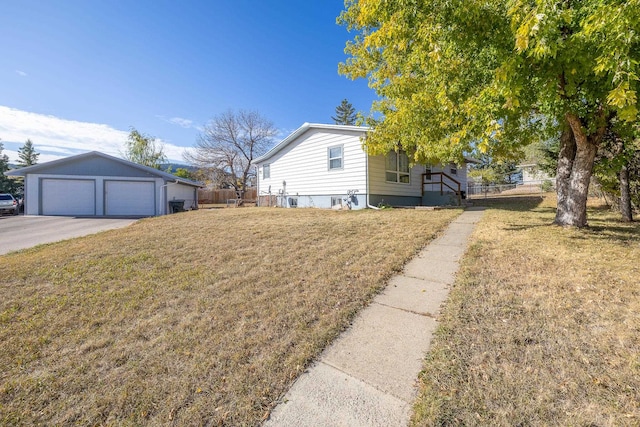 view of side of property featuring a yard, an outbuilding, and a garage