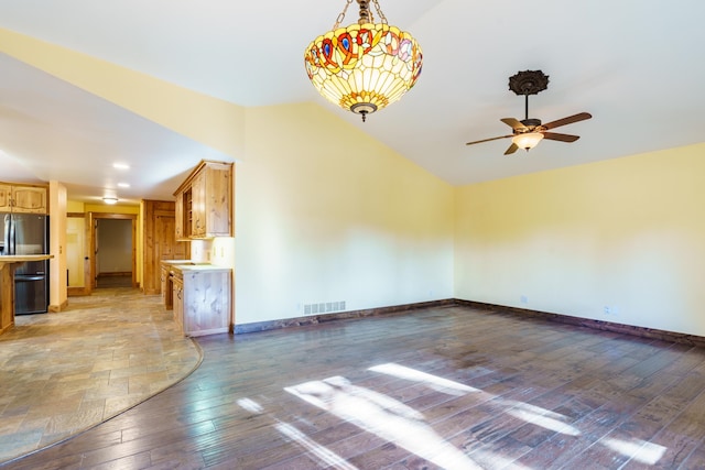 unfurnished living room featuring ceiling fan, wood-type flooring, and vaulted ceiling