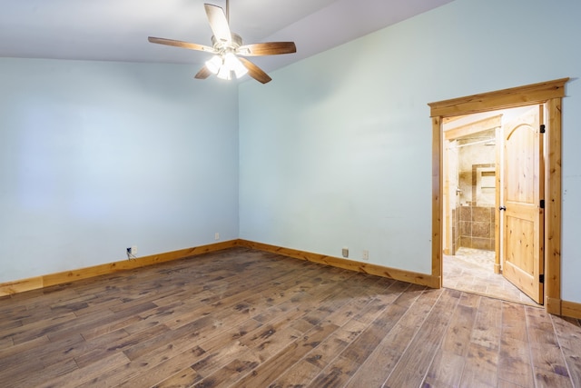 spare room with dark wood-type flooring, vaulted ceiling, and ceiling fan