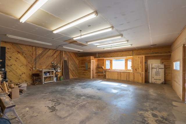 miscellaneous room featuring concrete floors and wooden walls