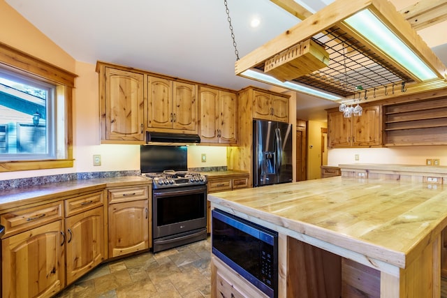 kitchen featuring butcher block counters, black appliances, and a center island