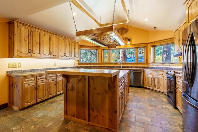 kitchen with a center island, decorative light fixtures, stainless steel appliances, and vaulted ceiling