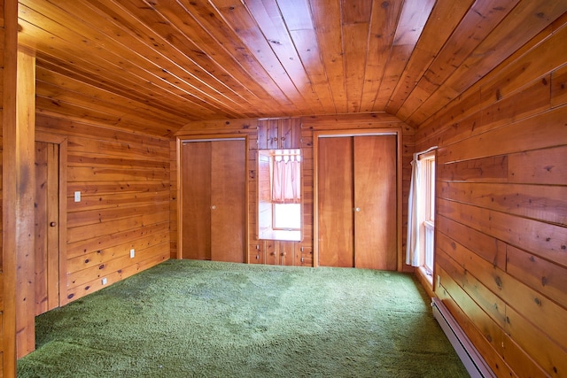 interior space featuring lofted ceiling, a baseboard heating unit, wood ceiling, and wood walls