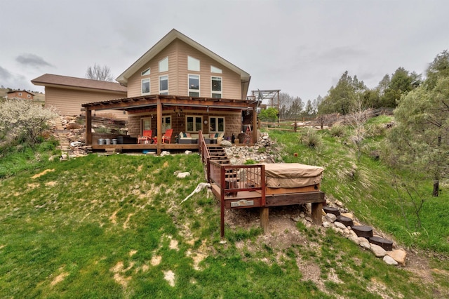 back of house featuring a deck and a lawn