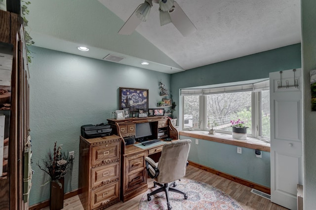 home office featuring light hardwood / wood-style flooring, vaulted ceiling, and ceiling fan