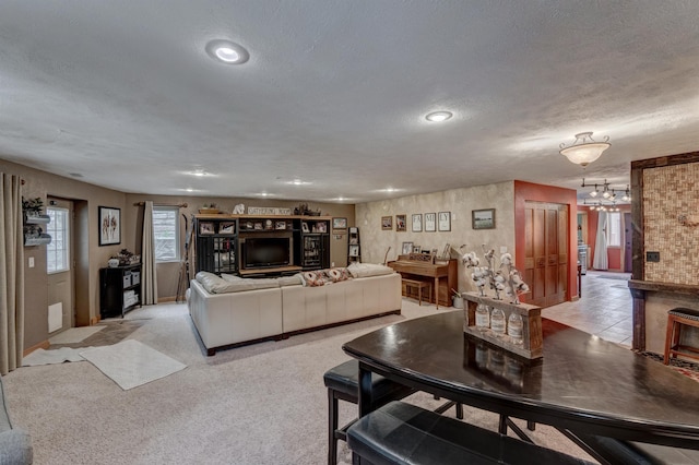 carpeted living room featuring a textured ceiling and a chandelier