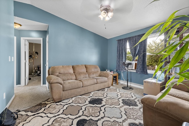 carpeted living room with ceiling fan and lofted ceiling