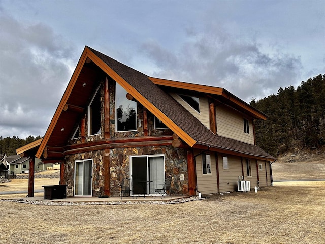 115 Minor Lake Cir, Hill City, SD 57745 - rear view of property with stone siding, roof with shingles, and a patio area