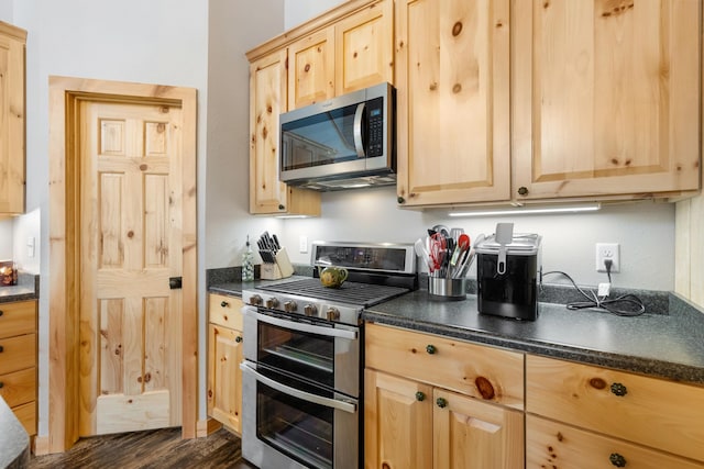 kitchen featuring dark wood-type flooring, light brown cabinetry, and appliances with stainless steel finishes