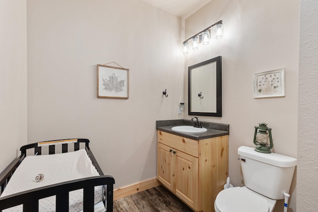 bathroom with vanity, hardwood / wood-style flooring, and toilet