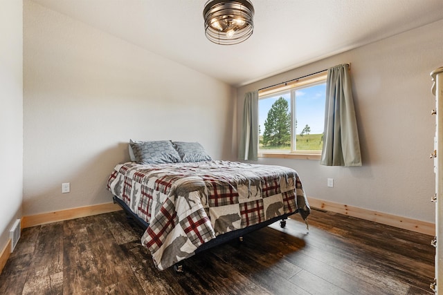 bedroom with lofted ceiling and dark hardwood / wood-style flooring