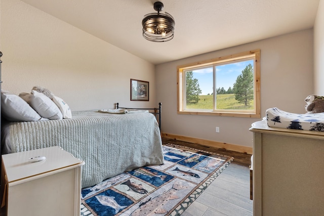 bedroom with lofted ceiling and light hardwood / wood-style flooring