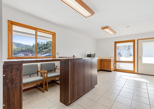 home office featuring a textured ceiling and light tile patterned flooring