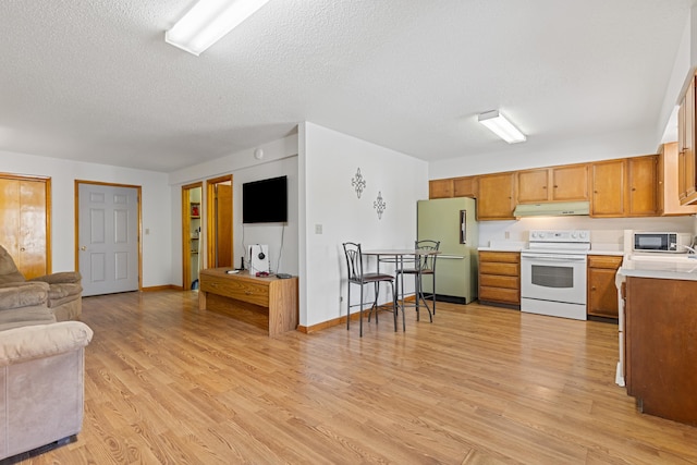 kitchen with refrigerator, a textured ceiling, light hardwood / wood-style floors, and white range with electric stovetop