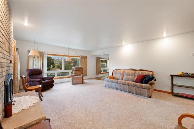 carpeted living room featuring a brick fireplace and baseboards
