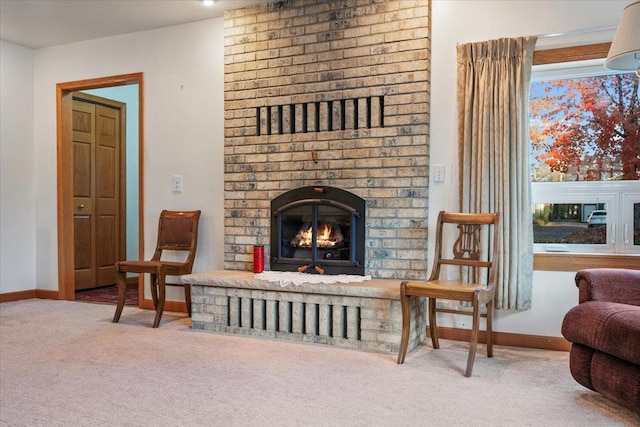living area featuring carpet, baseboards, and a brick fireplace