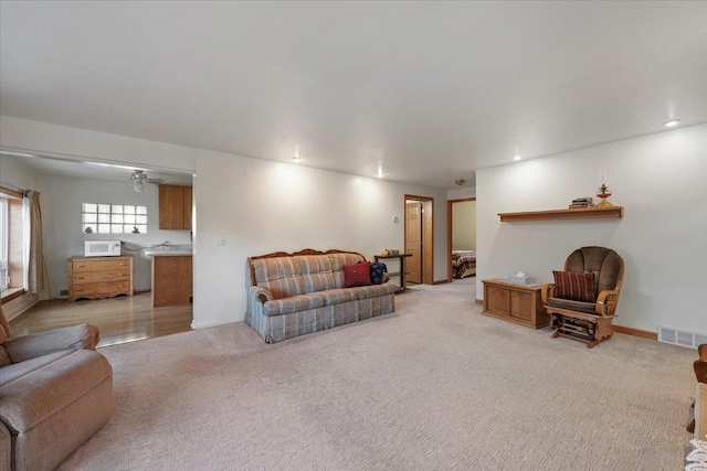 living room featuring light colored carpet, ceiling fan, and recessed lighting