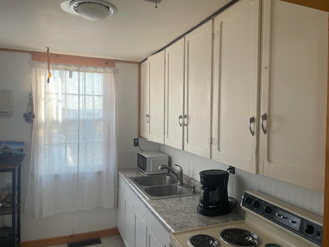 kitchen with white cabinets, sink, and white appliances