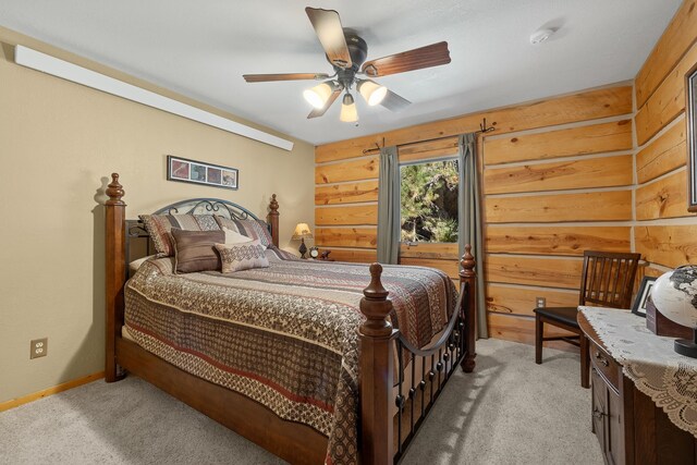 bedroom with wood walls, light colored carpet, and ceiling fan