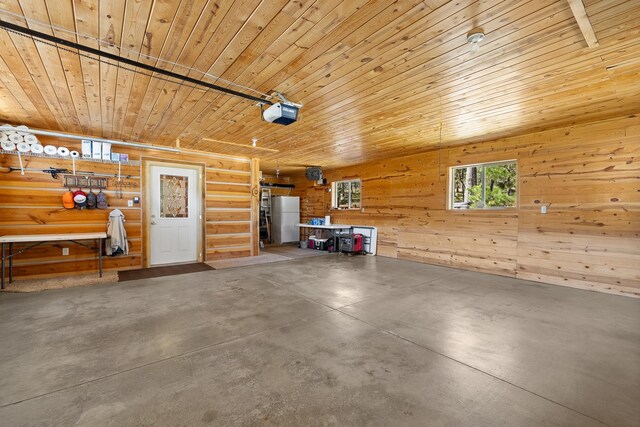 garage featuring a garage door opener, wood walls, white fridge, and wooden ceiling