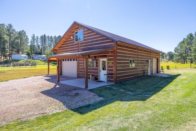 exterior space with a garage, an outdoor structure, and a lawn