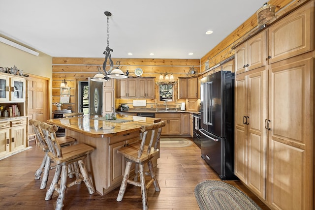 kitchen with stainless steel appliances, a center island, a breakfast bar area, sink, and dark hardwood / wood-style floors