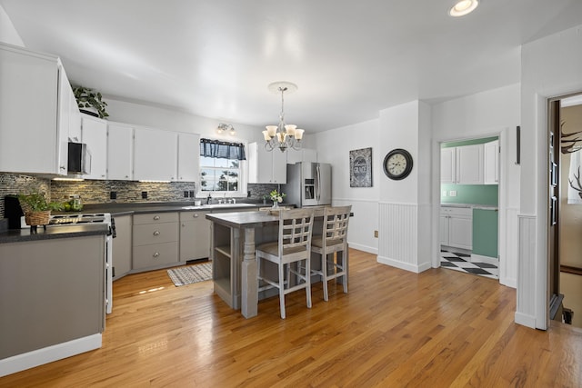 kitchen with a kitchen island, white cabinetry, light hardwood / wood-style floors, and stainless steel appliances