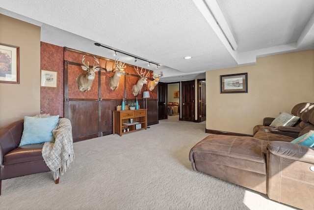 living room featuring track lighting, a textured ceiling, and carpet