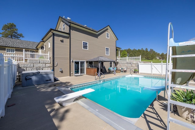 view of swimming pool with a diving board, a gazebo, a water slide, and a patio area