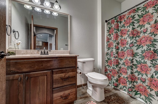 bathroom featuring toilet, vanity, and a shower with shower curtain