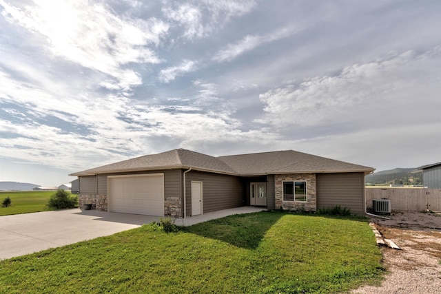 prairie-style home with a front lawn, central air condition unit, a garage, and a mountain view