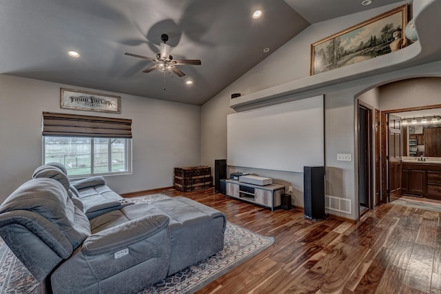 home theater room with ceiling fan, dark hardwood / wood-style floors, sink, and high vaulted ceiling