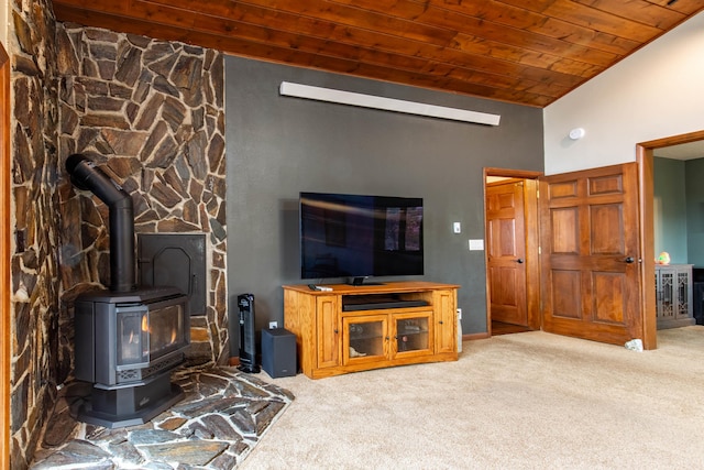 living room with high vaulted ceiling, wood ceiling, a wood stove, and light colored carpet