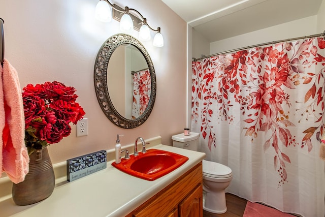 bathroom with hardwood / wood-style flooring, vanity, and toilet