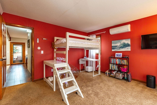 bedroom with a textured ceiling, wood-type flooring, and an AC wall unit