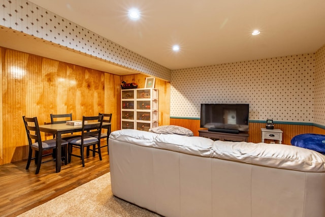 living room with wooden walls and hardwood / wood-style flooring