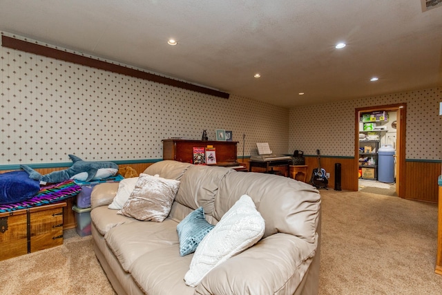 carpeted living room featuring wood walls