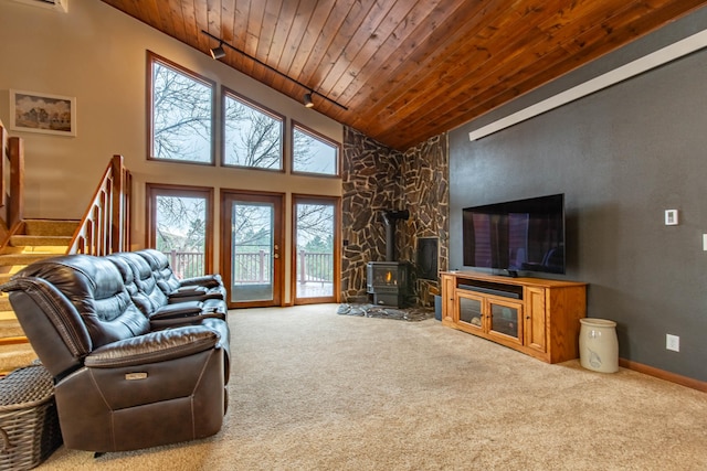 living room featuring a wood stove, high vaulted ceiling, a healthy amount of sunlight, and wood ceiling