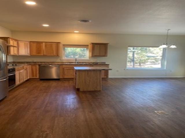 kitchen with pendant lighting, appliances with stainless steel finishes, dark wood-type flooring, and sink