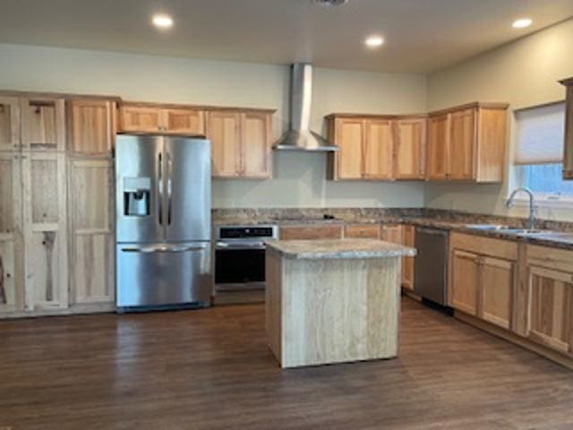 kitchen featuring sink, appliances with stainless steel finishes, wall chimney exhaust hood, a kitchen island, and dark hardwood / wood-style flooring