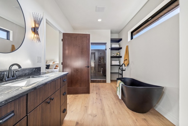 bathroom with hardwood / wood-style floors, vanity, and independent shower and bath