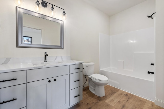 full bathroom with hardwood / wood-style floors, vanity, toilet, and shower / washtub combination